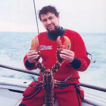Image of Skipper Mike Keane holding lobster found during a dive